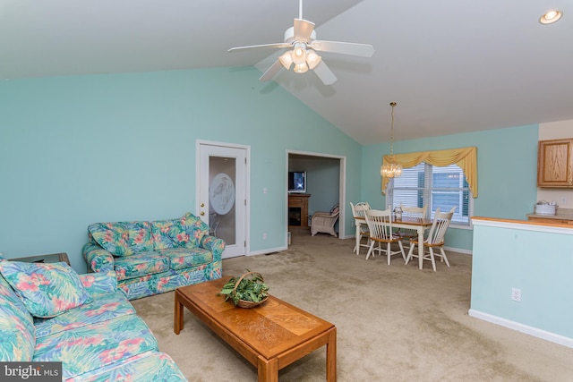 carpeted living room featuring ceiling fan with notable chandelier and lofted ceiling