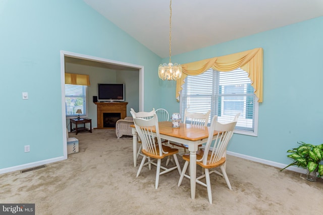 carpeted dining room with lofted ceiling