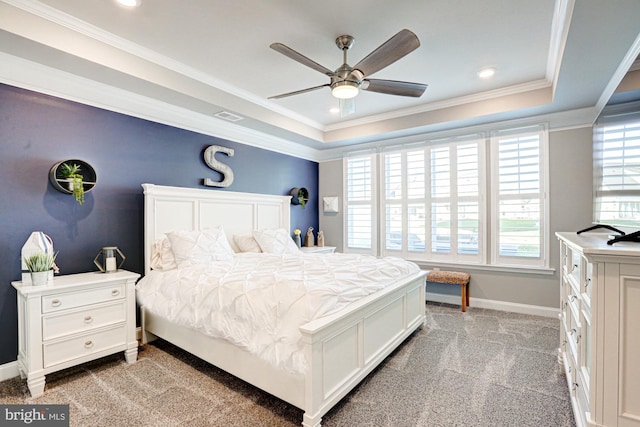 bedroom featuring ornamental molding, light colored carpet, a tray ceiling, and ceiling fan