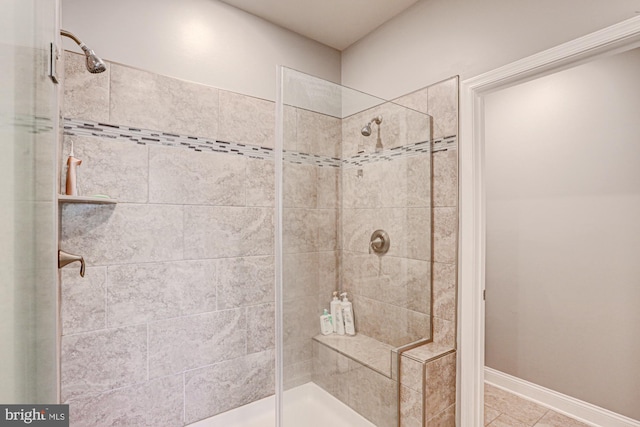 bathroom featuring tiled shower and tile patterned floors