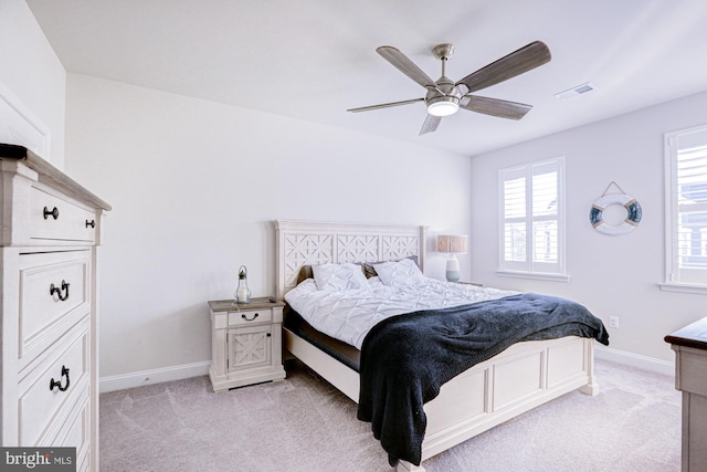 carpeted bedroom with multiple windows and ceiling fan