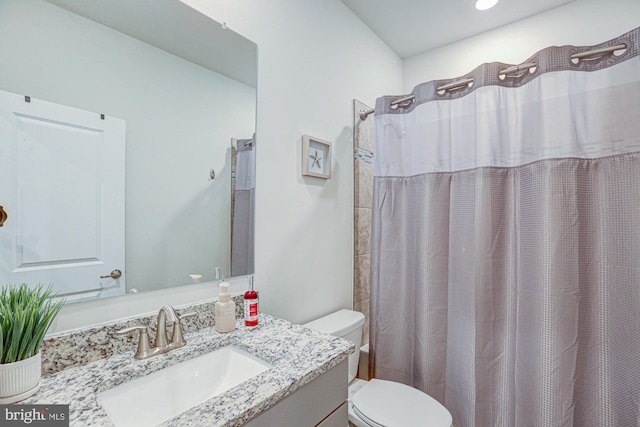 bathroom featuring toilet, walk in shower, and vanity