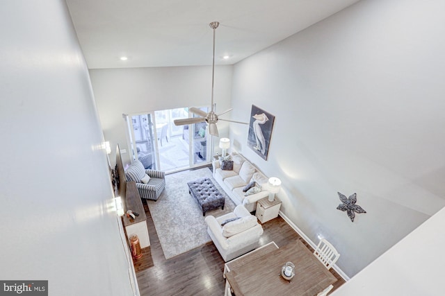 living room featuring ceiling fan, high vaulted ceiling, and dark hardwood / wood-style floors