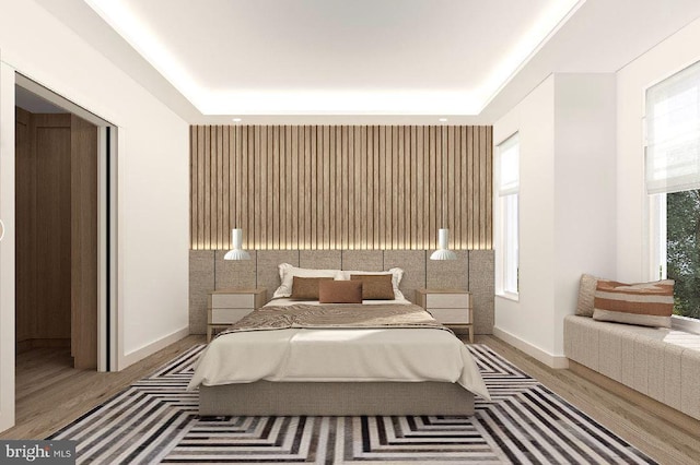 bedroom featuring hardwood / wood-style floors and a tray ceiling