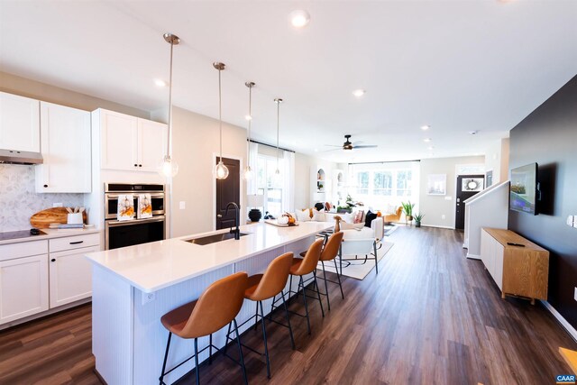 kitchen featuring white cabinetry, dark wood-type flooring, pendant lighting, and stainless steel double oven