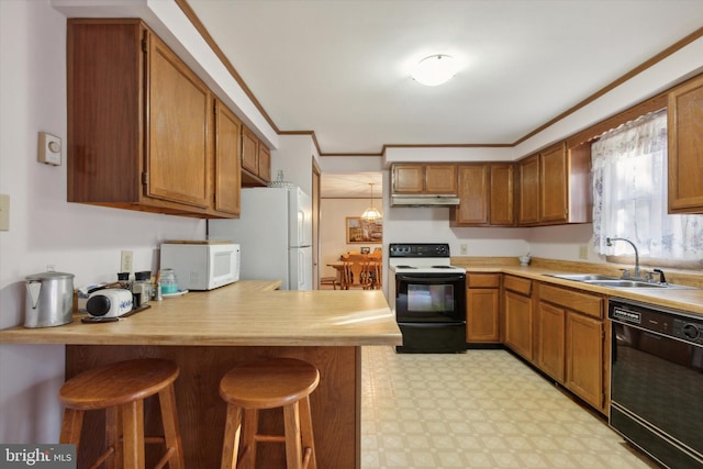 kitchen featuring kitchen peninsula, a kitchen bar, black appliances, crown molding, and sink