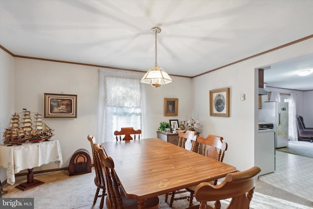 carpeted dining space featuring crown molding