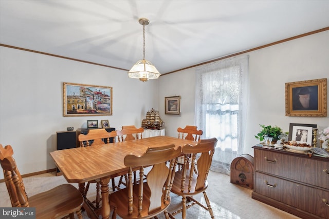 dining space with ornamental molding and light colored carpet