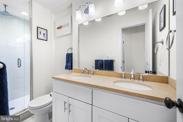 bathroom with vanity, toilet, and a shower with door