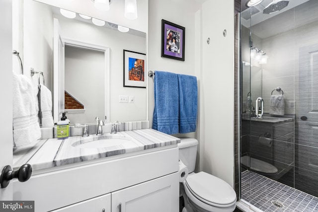 bathroom with walk in shower, vanity, and toilet