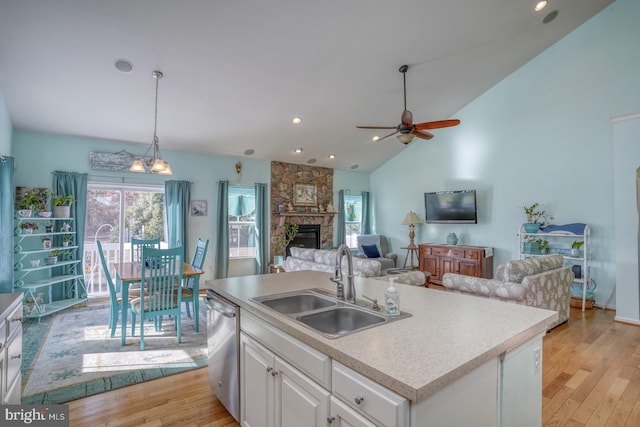 kitchen featuring light hardwood / wood-style floors, white cabinetry, a kitchen island with sink, and dishwasher