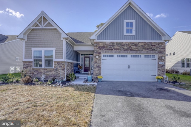 craftsman inspired home featuring a garage and a front lawn