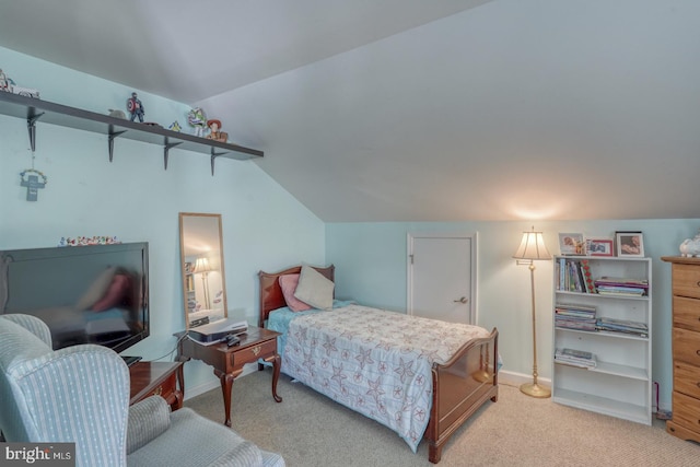 bedroom with light colored carpet and vaulted ceiling