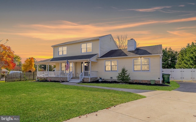 view of front of property with a porch and a yard