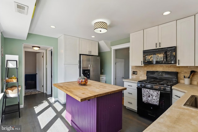 kitchen with black appliances, dark hardwood / wood-style flooring, decorative backsplash, and white cabinets