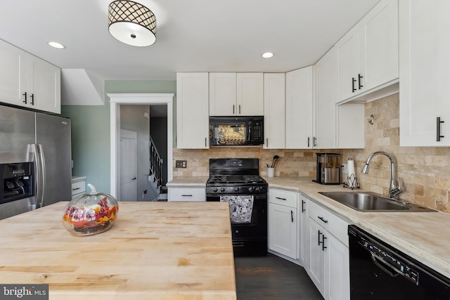 kitchen featuring black appliances, sink, decorative backsplash, and white cabinets