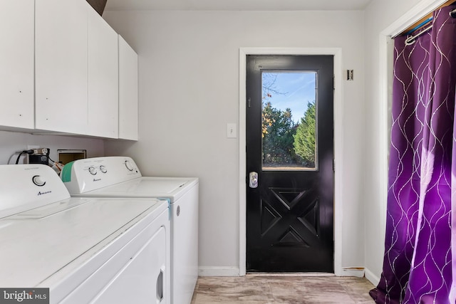 laundry room featuring light hardwood / wood-style flooring, washer and dryer, and cabinets