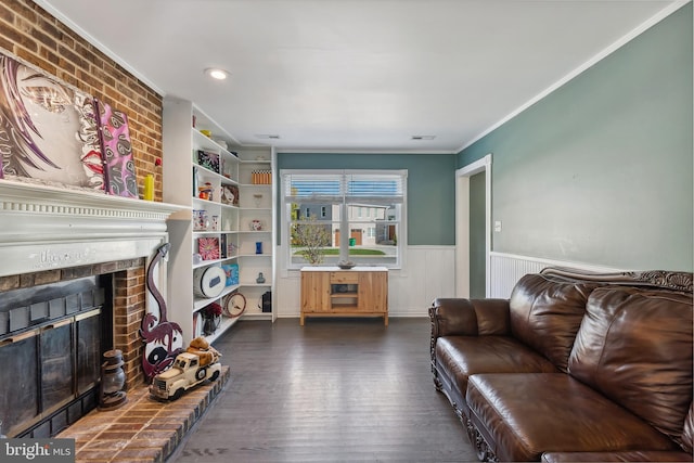 living room featuring crown molding, dark wood-type flooring, and a fireplace