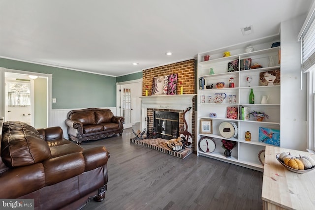 living room featuring a fireplace, ornamental molding, dark wood-type flooring, and plenty of natural light