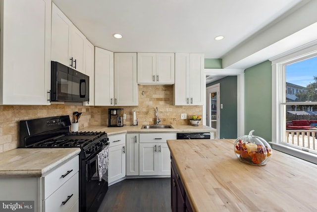 kitchen with dark wood-type flooring, wood counters, sink, black appliances, and white cabinets