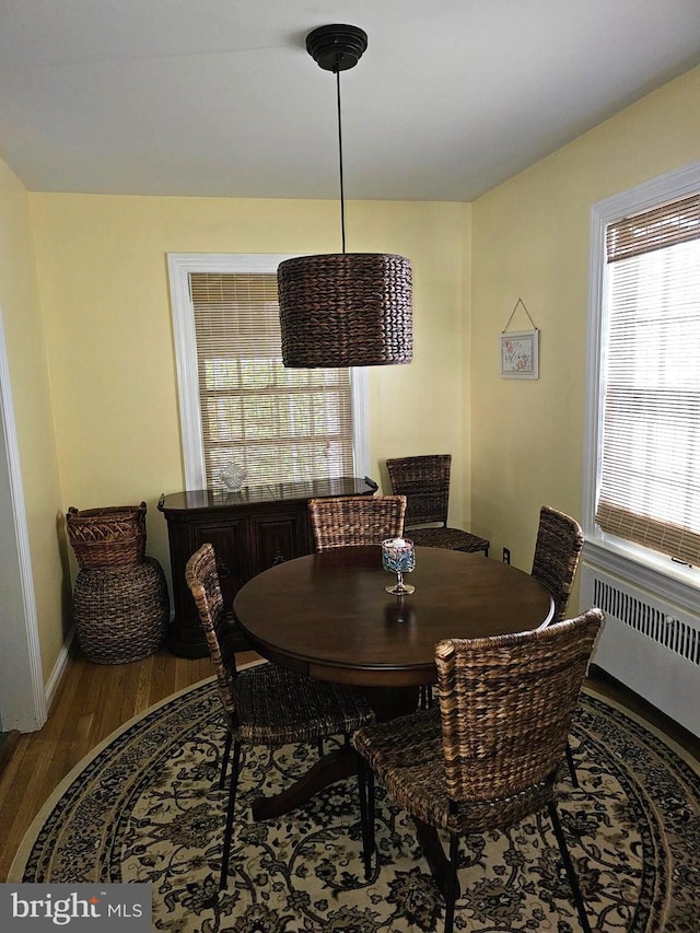 dining room with radiator heating unit and hardwood / wood-style floors