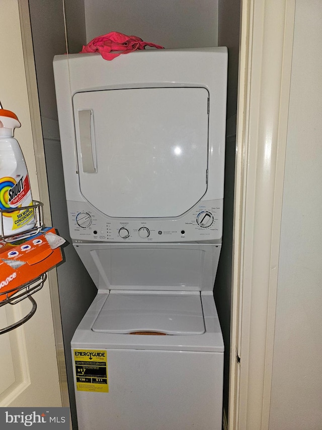 washroom featuring stacked washing maching and dryer