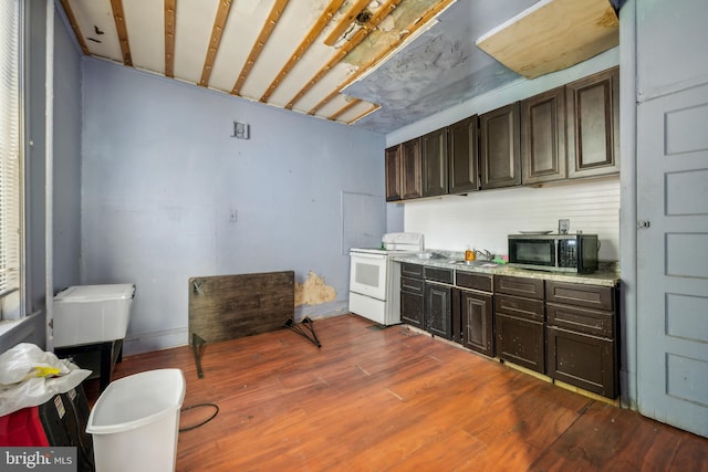 kitchen featuring dark hardwood / wood-style floors, sink, dark brown cabinets, and electric stove