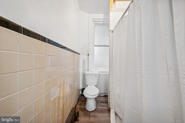 bathroom featuring tile walls, wood-type flooring, and toilet