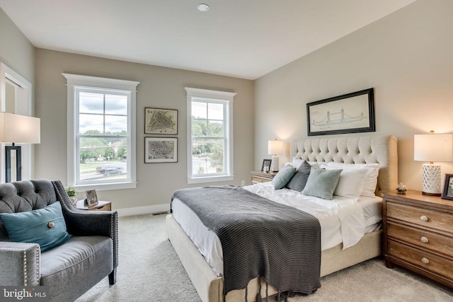 bedroom featuring baseboards and light colored carpet
