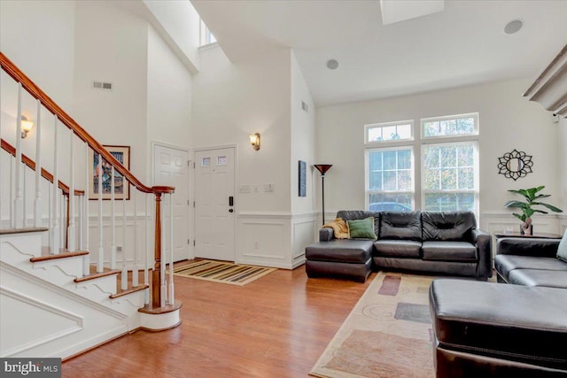 living room with high vaulted ceiling and light hardwood / wood-style floors