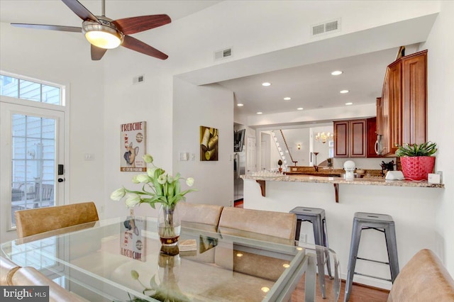 dining area with hardwood / wood-style floors and ceiling fan