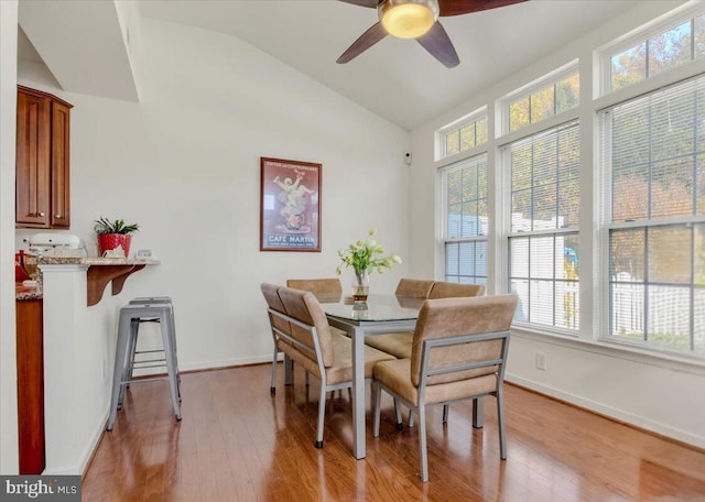 dining area featuring vaulted ceiling, a wealth of natural light, light wood-type flooring, and ceiling fan