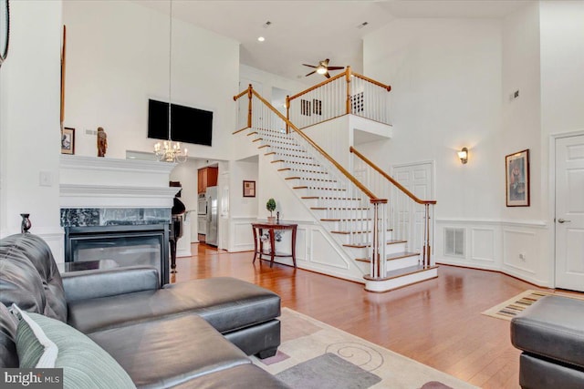 living room featuring high vaulted ceiling, a high end fireplace, and hardwood / wood-style floors