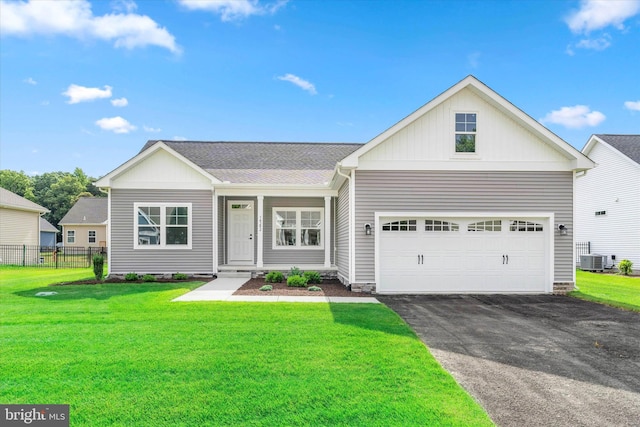 view of front of property with central AC, a garage, and a front lawn