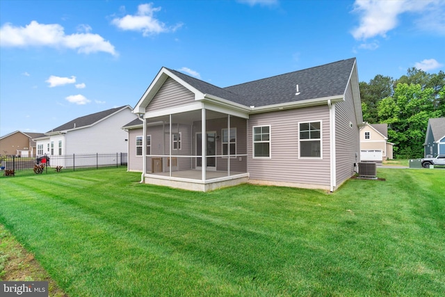 back of property featuring central AC unit, a lawn, and a sunroom