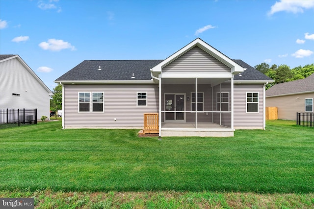 rear view of property with a lawn and a sunroom