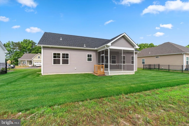 rear view of property featuring a lawn and a sunroom