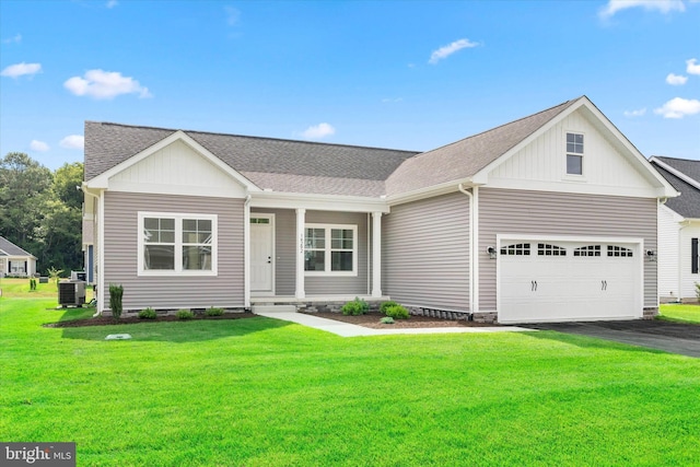 view of front of house with a front lawn, central AC, and a garage