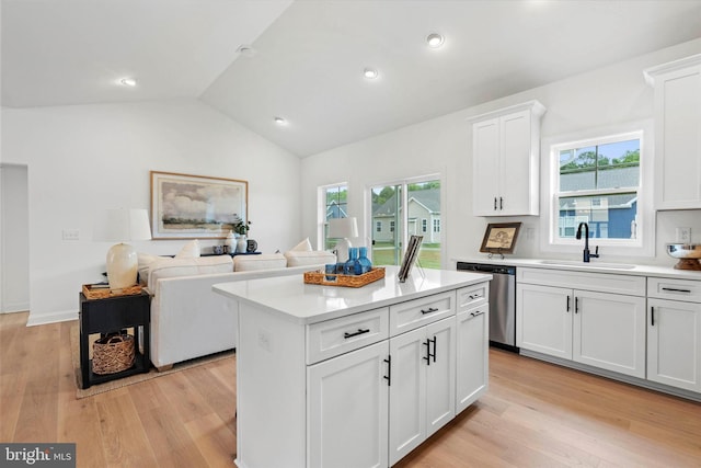 kitchen with dishwasher, white cabinets, sink, and a healthy amount of sunlight