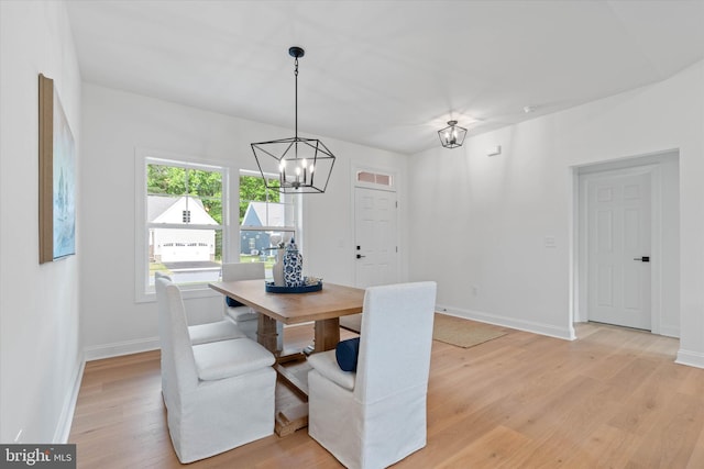 dining space featuring an inviting chandelier and light wood-type flooring