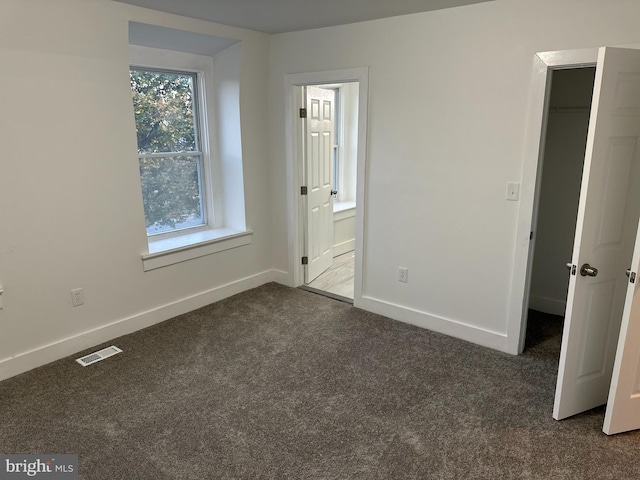 unfurnished bedroom featuring dark colored carpet