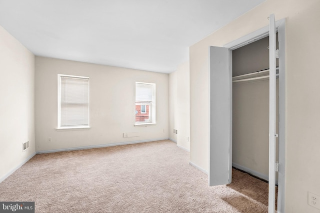 unfurnished bedroom featuring a closet and light carpet