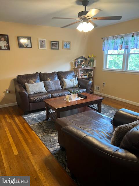 living room featuring ceiling fan and hardwood / wood-style flooring