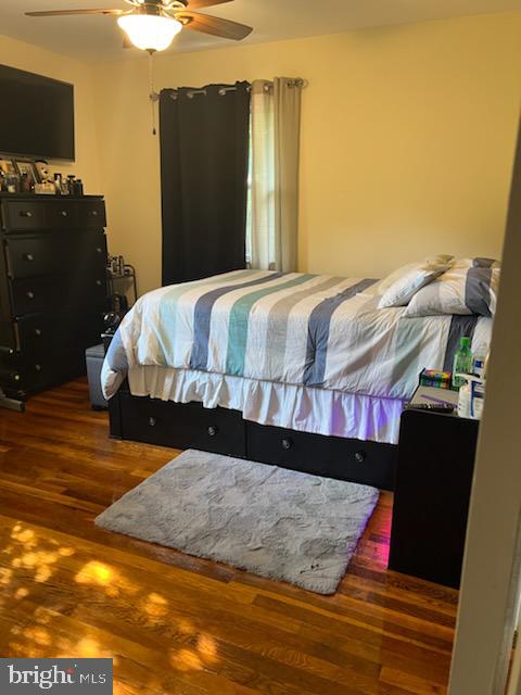 bedroom with ceiling fan and dark hardwood / wood-style flooring