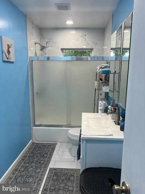 full bathroom featuring vanity, enclosed tub / shower combo, and toilet