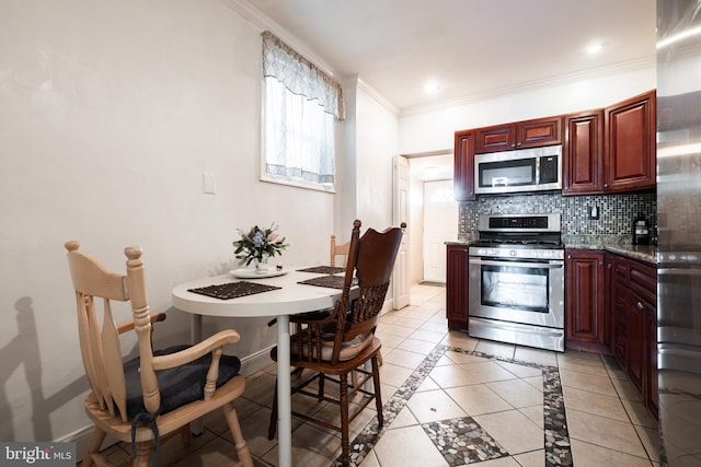 kitchen featuring backsplash, appliances with stainless steel finishes, light tile patterned floors, and ornamental molding