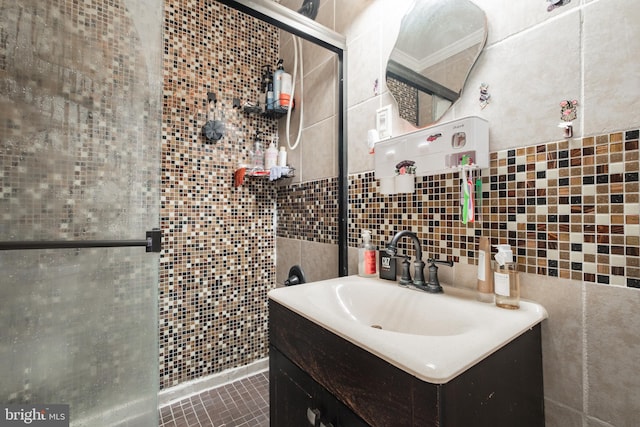 bathroom featuring vanity, tile walls, ornamental molding, and a shower with shower door