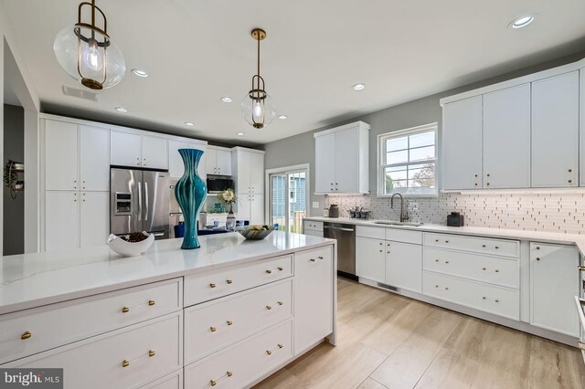 kitchen with light wood-style floors, a sink, wall chimney exhaust hood, and high end stainless steel range oven
