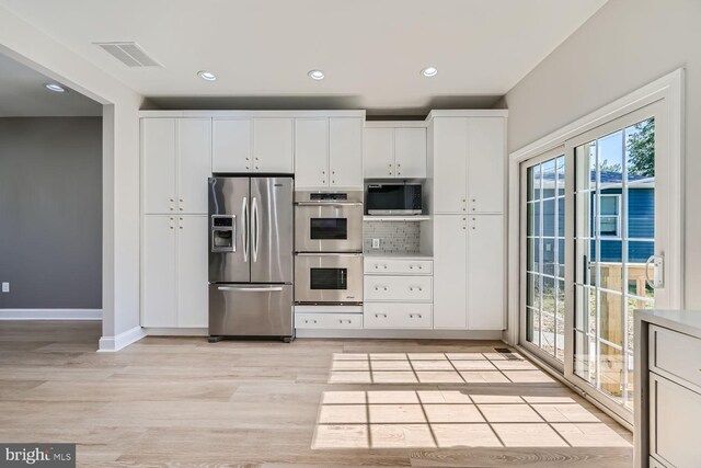 kitchen featuring light hardwood / wood-style flooring, white cabinetry, stainless steel appliances, and a water view