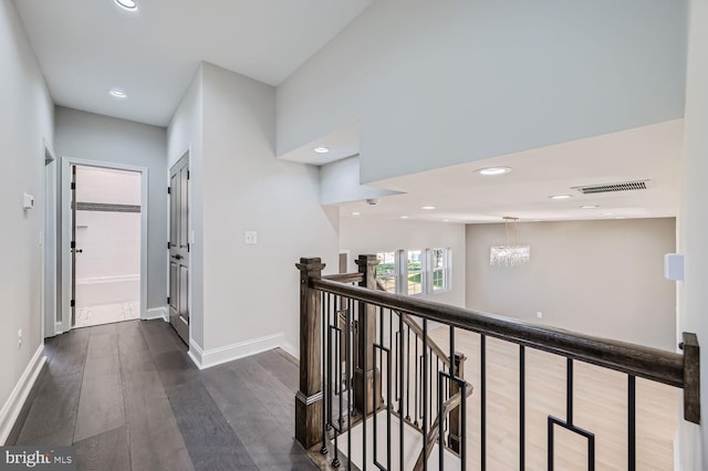 hall featuring a notable chandelier and dark wood-type flooring